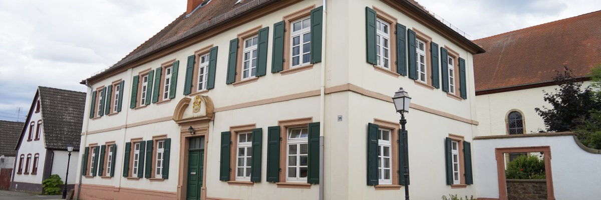Rathaus der Ortsgemeinde Freisbach mit Blick auf den Kirchturm Rathaus der Ortsgemeinde Freisbach mit Blick auf den Kirchturm