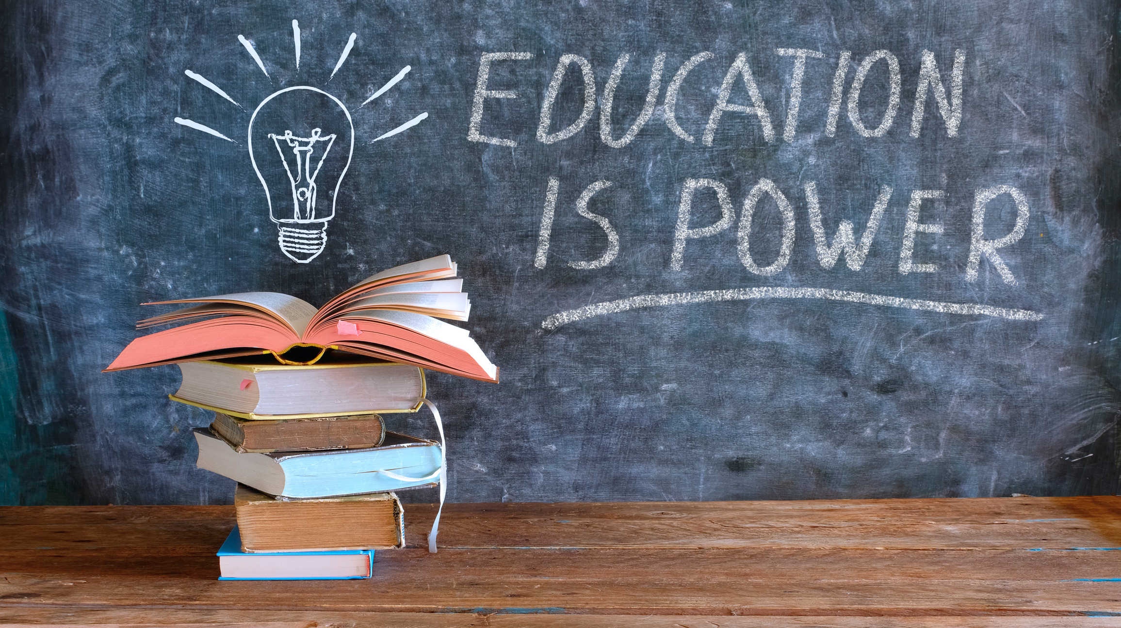 books and blackboard with drawing of a lightbulb and slogan education is power,learning,knowledge,back to school concept books and blackboard with drawing of a lightbulb and slogan education is power,learning,knowledge,back to school concept