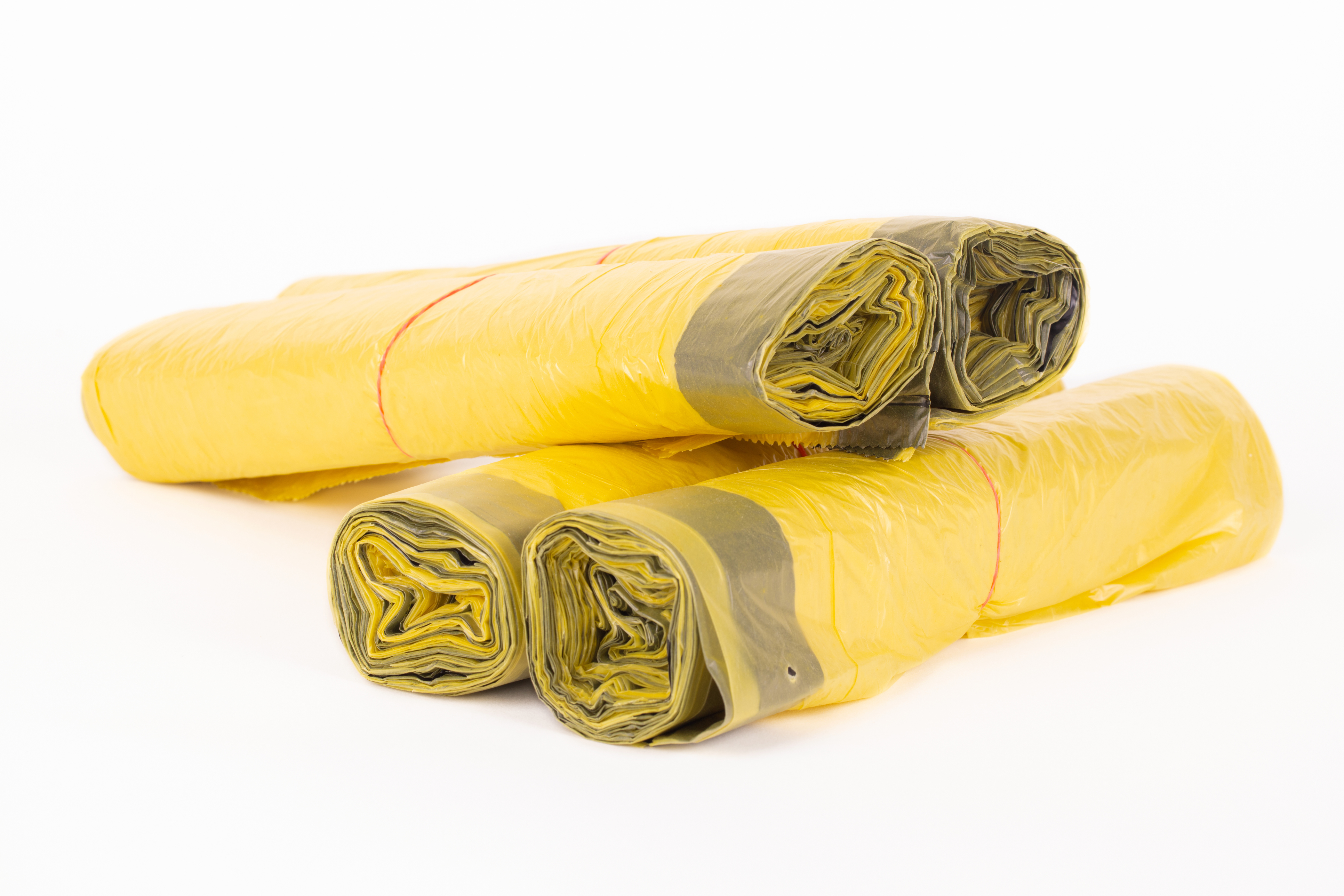 Rolls of yellow trash bags on white background Rolls of yellow trash bags on white background