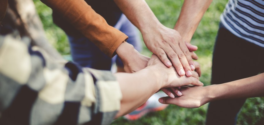 Stacking hands of young teen student, teamwork, togetherness and cooperation concept