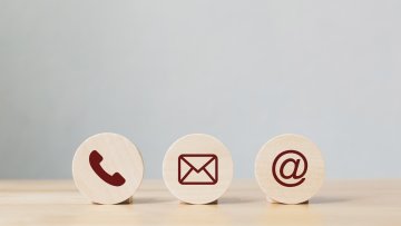 Wooden coins with symbol telephone, email, address. Website page contact us or e-mail marketing concept