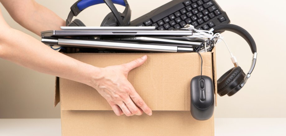 Woman hands holding cardboard box full old used computers, phones, tablets, gadget devices for recycling. Planned obsolescence, e-waste, donation, electronic waste for reuse and recycle concept