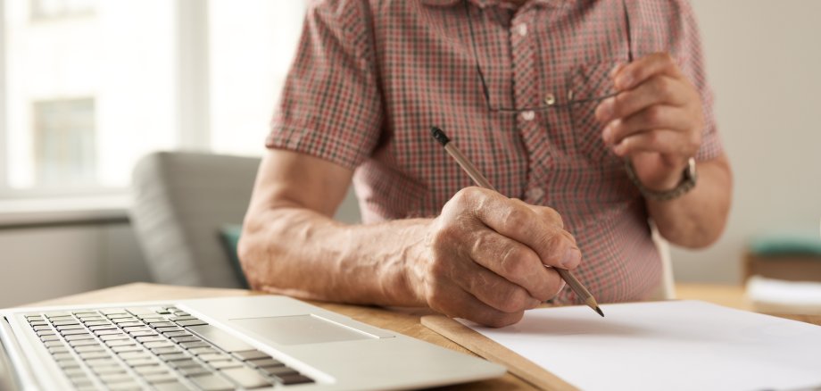 Senior Man Filling Forms at Home