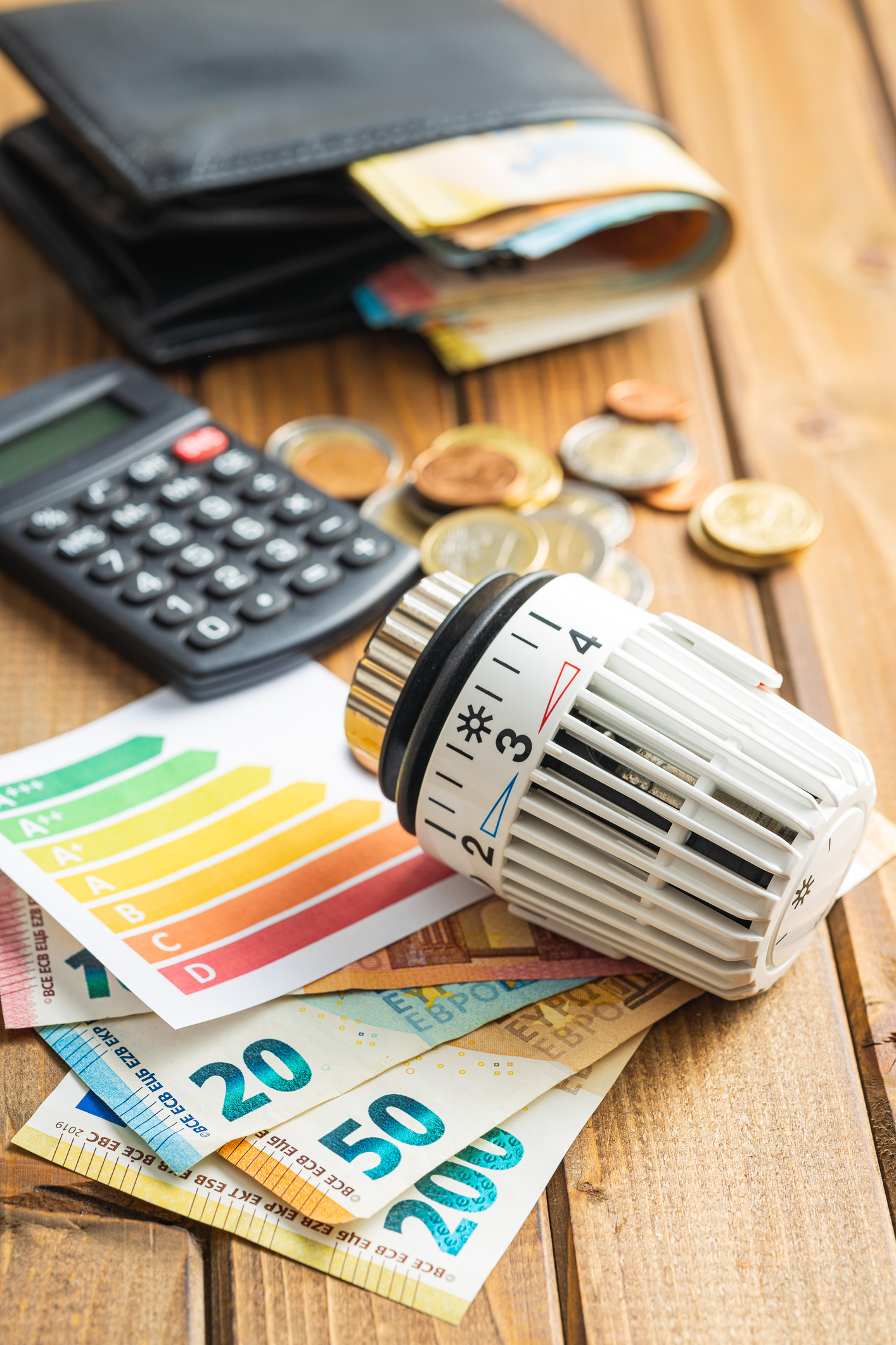 Thermostatic valve head, euro money and energy label on wooden table. Thermostatic valve head, euro money and energy label on wooden table.