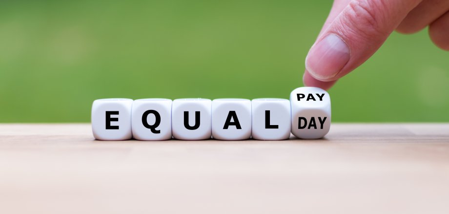 Symbol for the equal pay day. Dice form the expression "EQUAL PAY DAY".