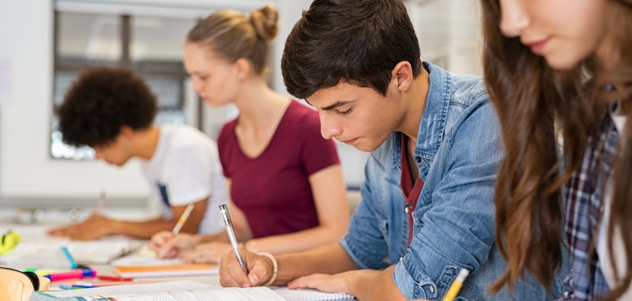 High school students doing exam in classroom