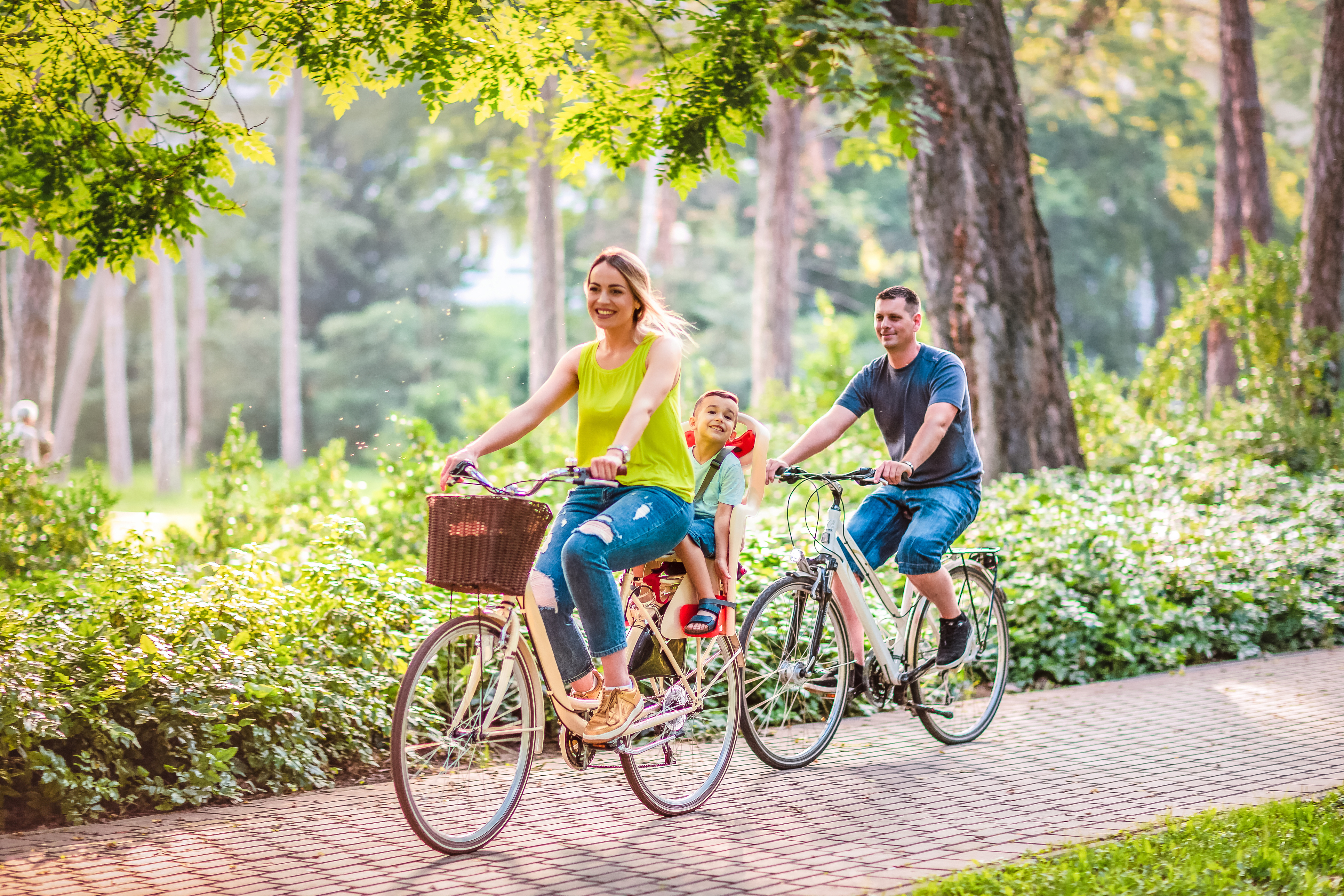 Happy father and mother with kid on bicycles having fun in park. Happy father and mother with kid on bicycles having fun in park.