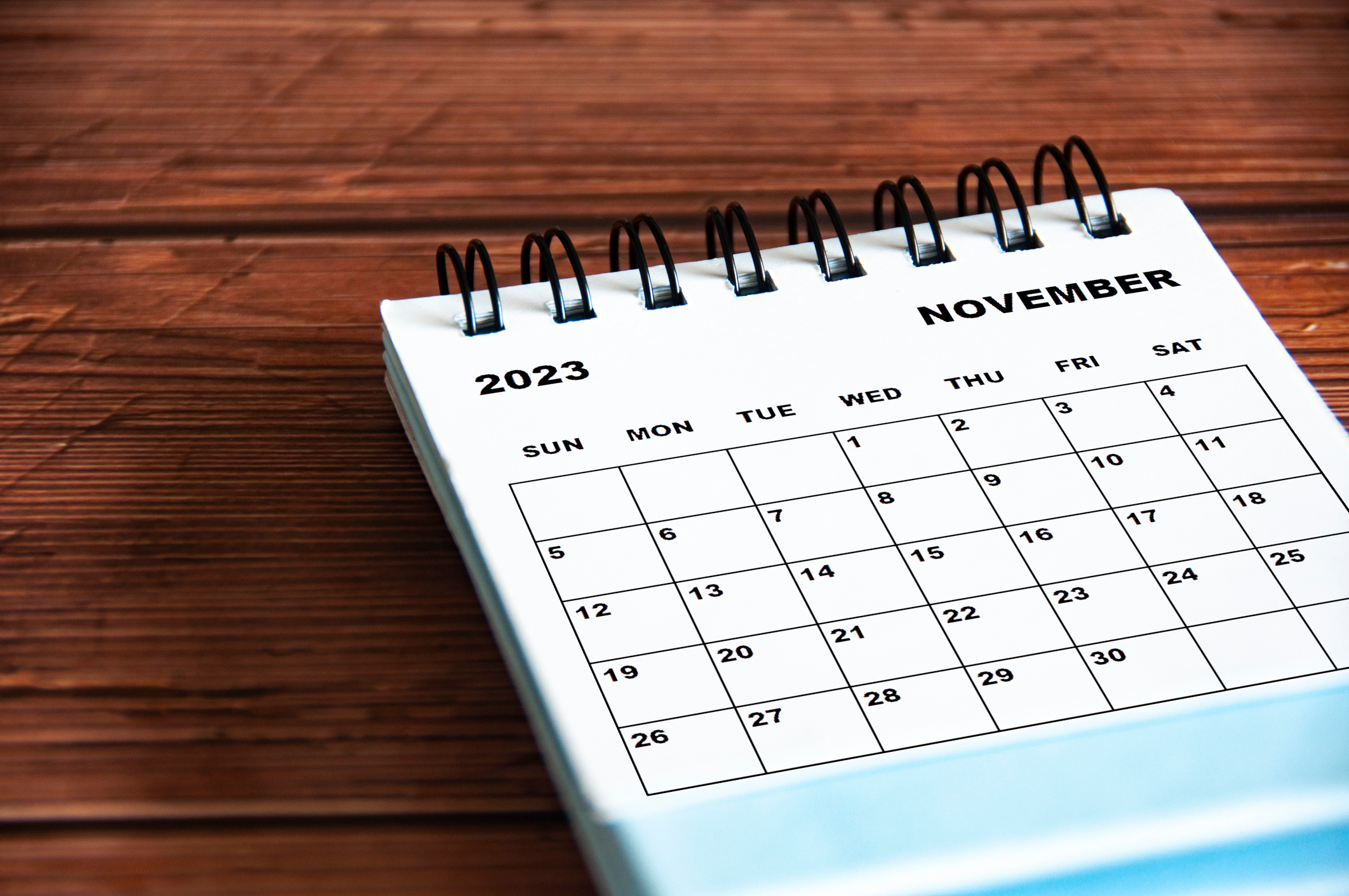 November 2023 white desk calendar on wooden table background. Calendar concept and copy space November 2023 white desk calendar on wooden table background. Calendar concept and copy space