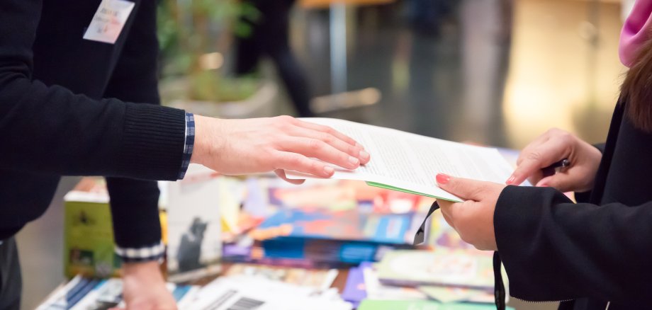 Man and Woman Sharing Information Leaflet over Exhibition Stand