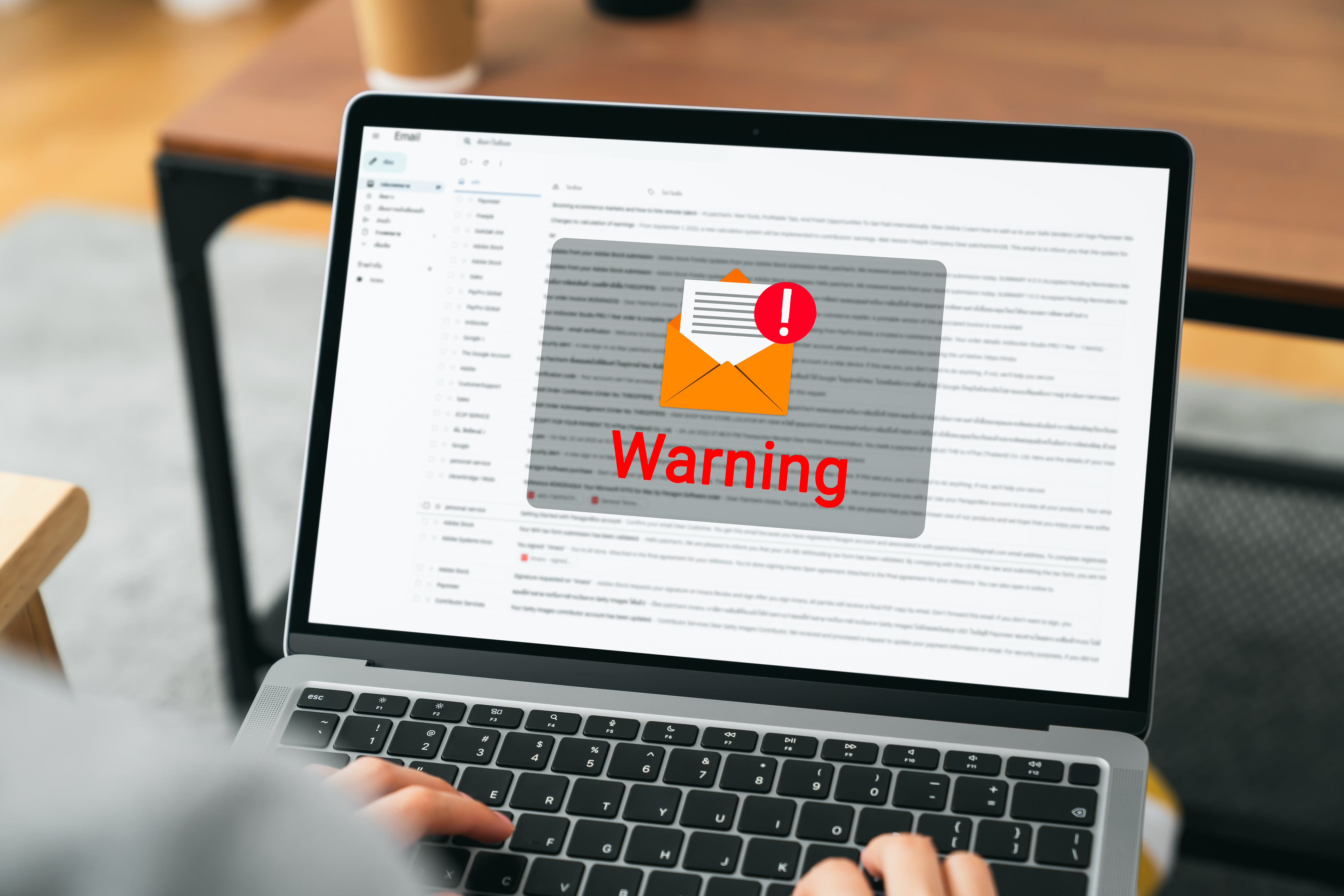 Hand using laptop with shows a warning screen of new email notifications, hack password and personal data. Concept of cyber crime Hand using laptop with shows a warning screen of new email notifications, hack password and personal data. Concept of cyber crime