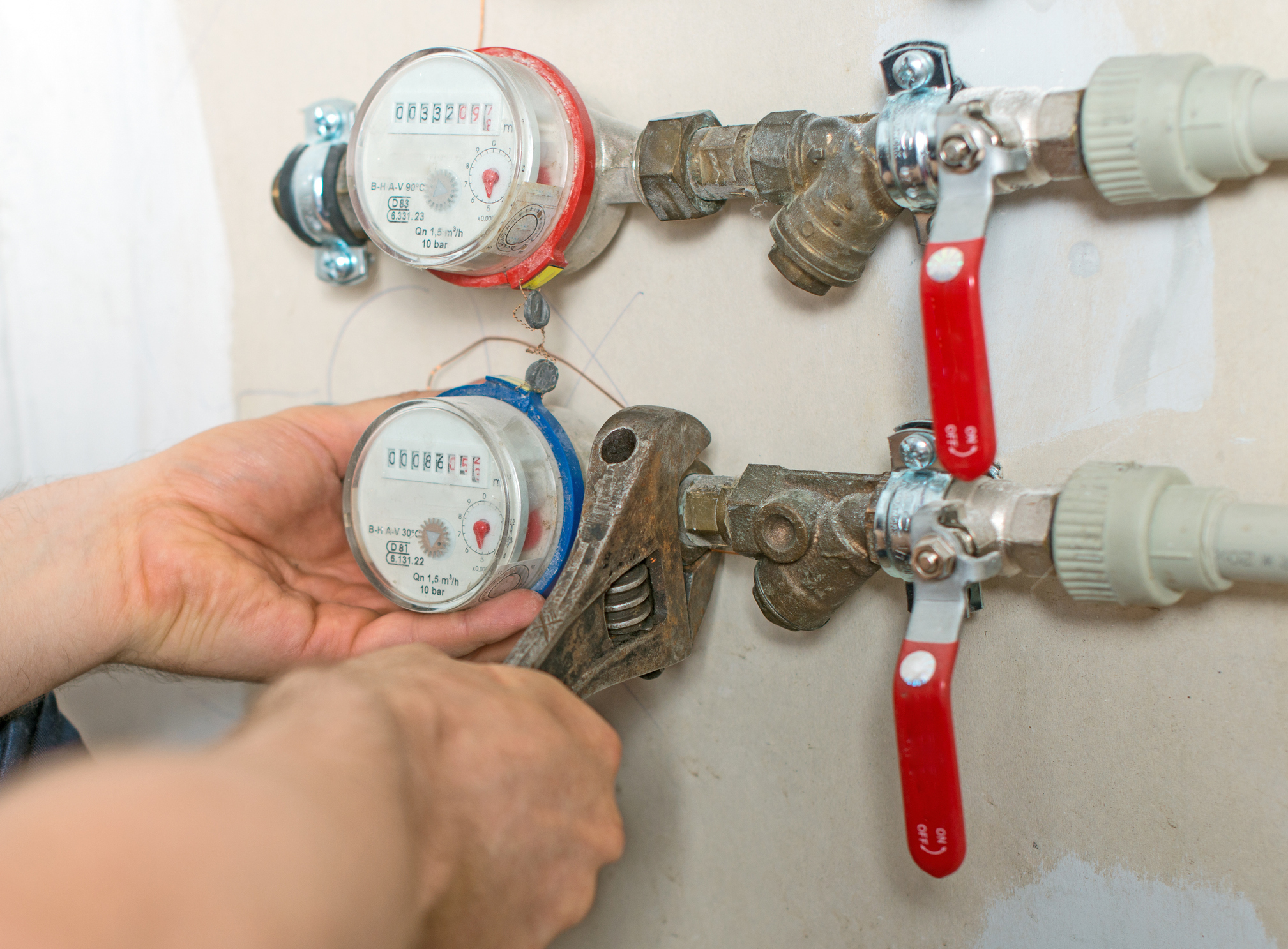 Male plumber fixing water meter with adjustable wrench. Male plumber fixing water meter with adjustable wrench.