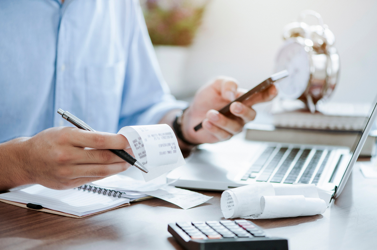 young man holding pen with bills working for calculate business data, taxes, bills payment, Start up counting finance. accounting, statistics, and analytic research concept young man holding pen with bills working for calculate business data, taxes, bills payment, Start up counting finance. accounting, statistics, and analytic research concept