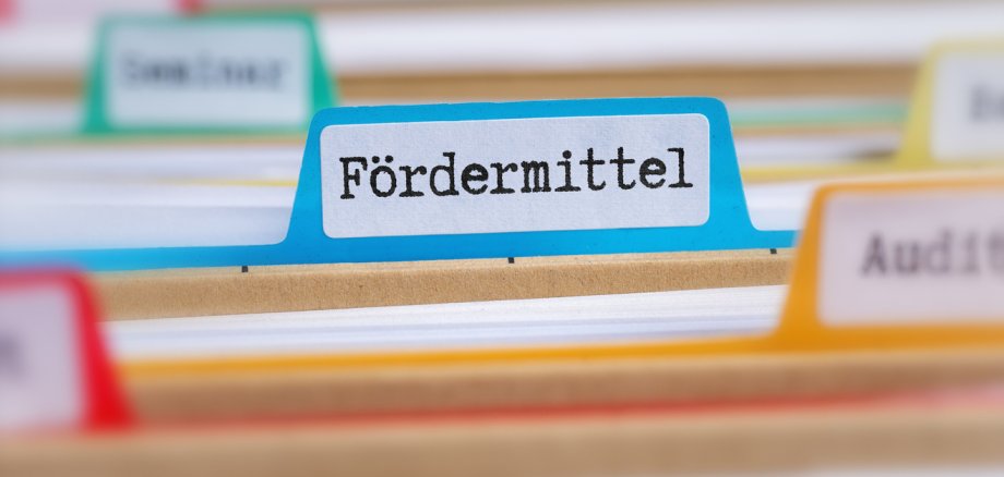 File folders with a tab labeled Funding in german - Fördermittel