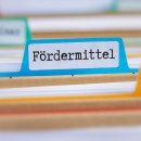 File folders with a tab labeled Funding in german - Fördermittel File folders with a tab labeled Funding in german - Fördermittel