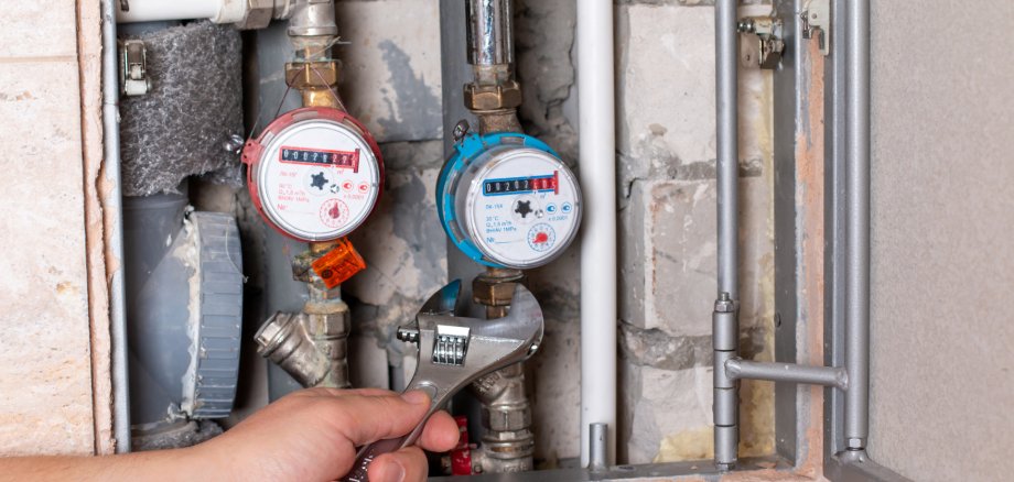 Plumber's hands with wrench while repairing pipes