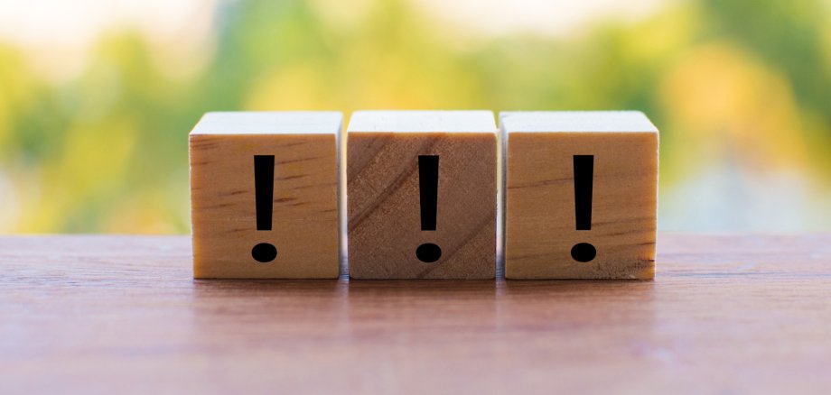 3 wooden dice arranged in an exclamation mark