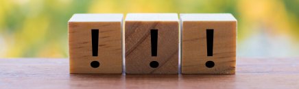 3 wooden dice arranged in an exclamation mark
