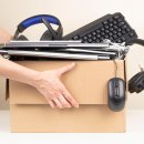 Woman hands holding cardboard box full old used computers, phones, tablets, gadget devices for recycling. Planned obsolescence, e-waste, donation, electronic waste for reuse and recycle concept