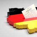 Elections in Germany. A sample ballot paper for the election to the Bundestag in the slit of a ballot box in the form of the German map with the German flag. 3d render, gray background, copy space