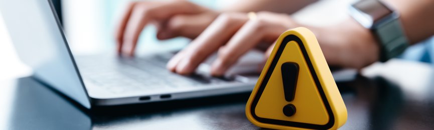 Warning sign placed on a table while businesswoman work.