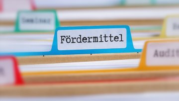 File folders with a tab labeled Funding in german - Fördermittel