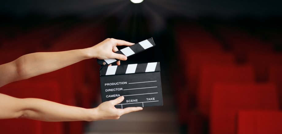 Hands Holding Director Movie Clapper in Cinema Theatre