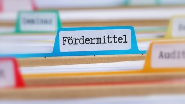 File folders with a tab labeled Funding in german - Fördermittel