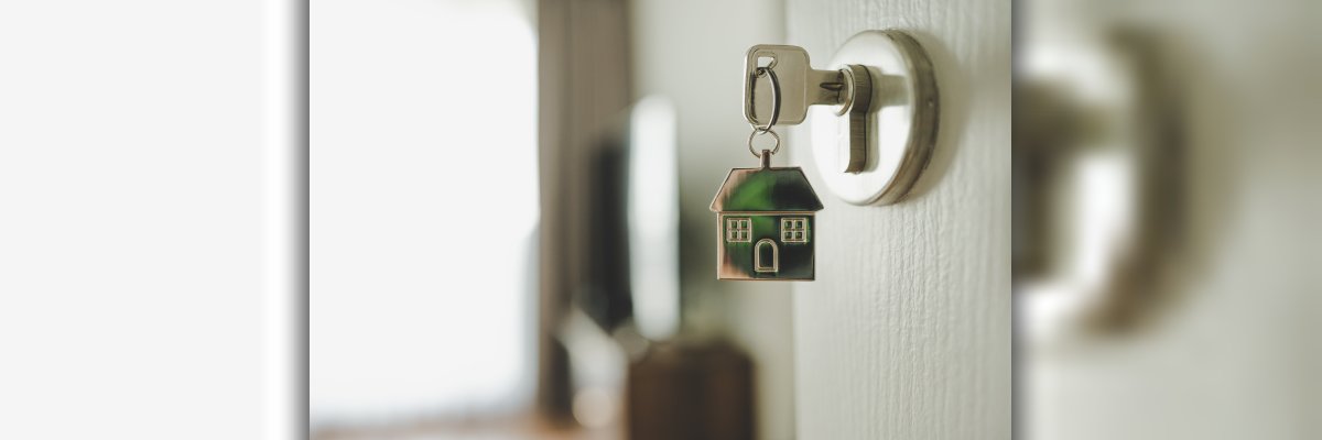 Open the door and door handle with a key and a keychain shaped house. Property investment and house mortgage financial real estate concept Open the door and door handle with a key and a keychain shaped house. Property investment and house mortgage financial real estate concept